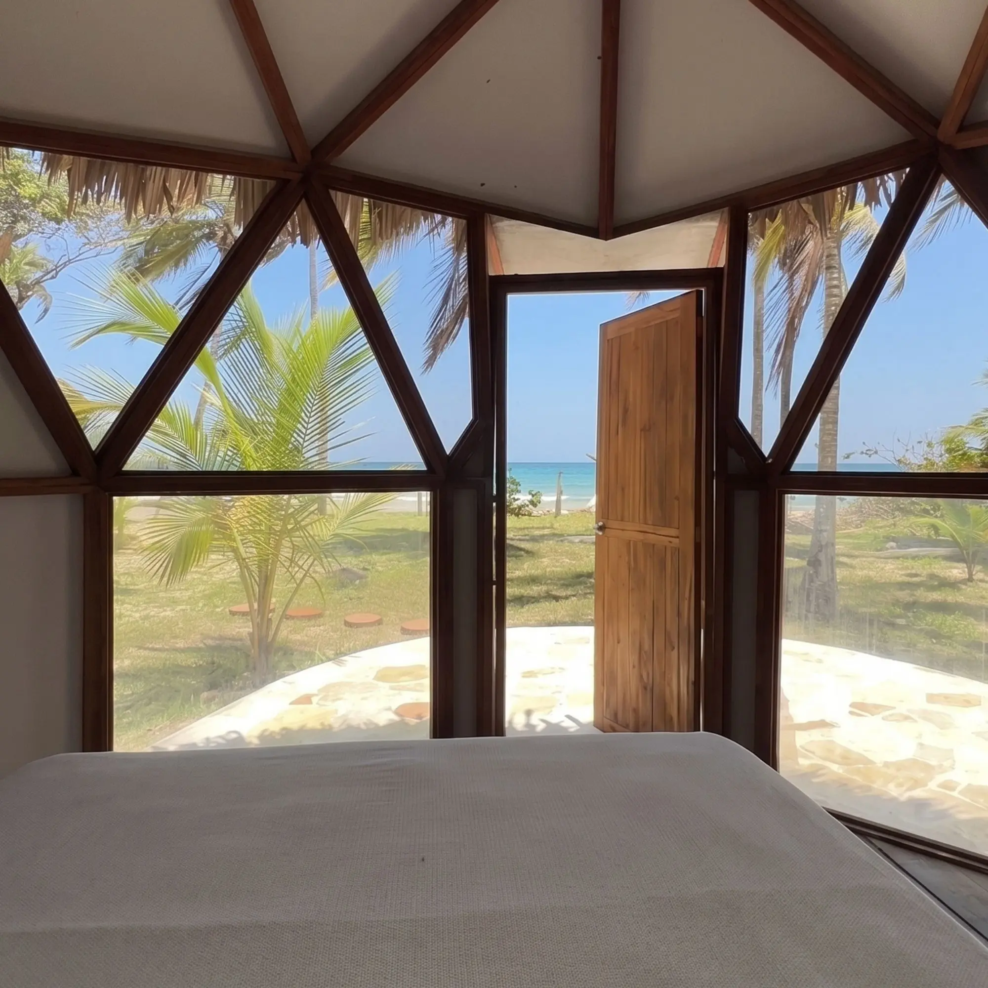Vista al mar desde la cama del glamping, amanecer – Genn Tayrona